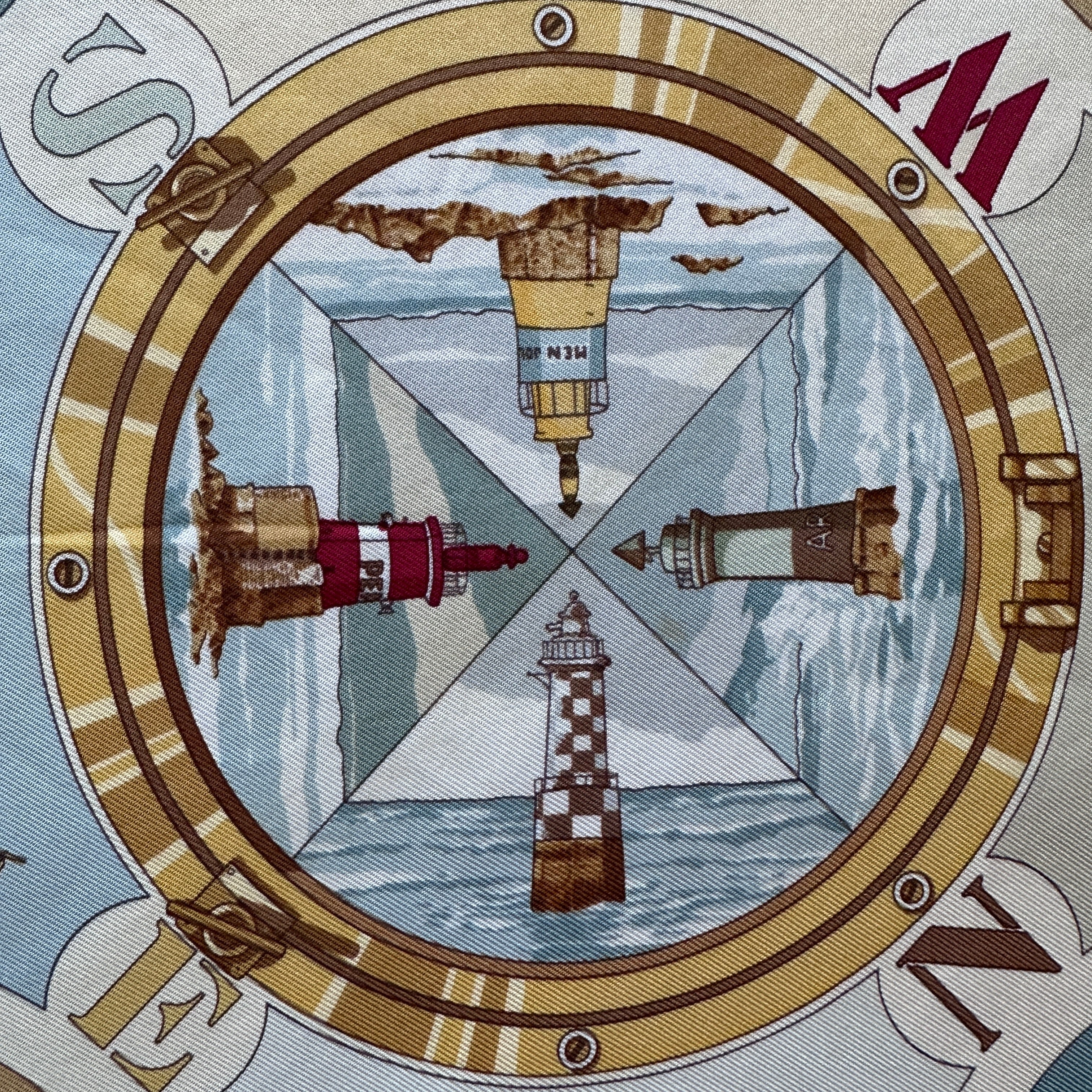 Médaillon central représentant une rose des vents et quatre phares.