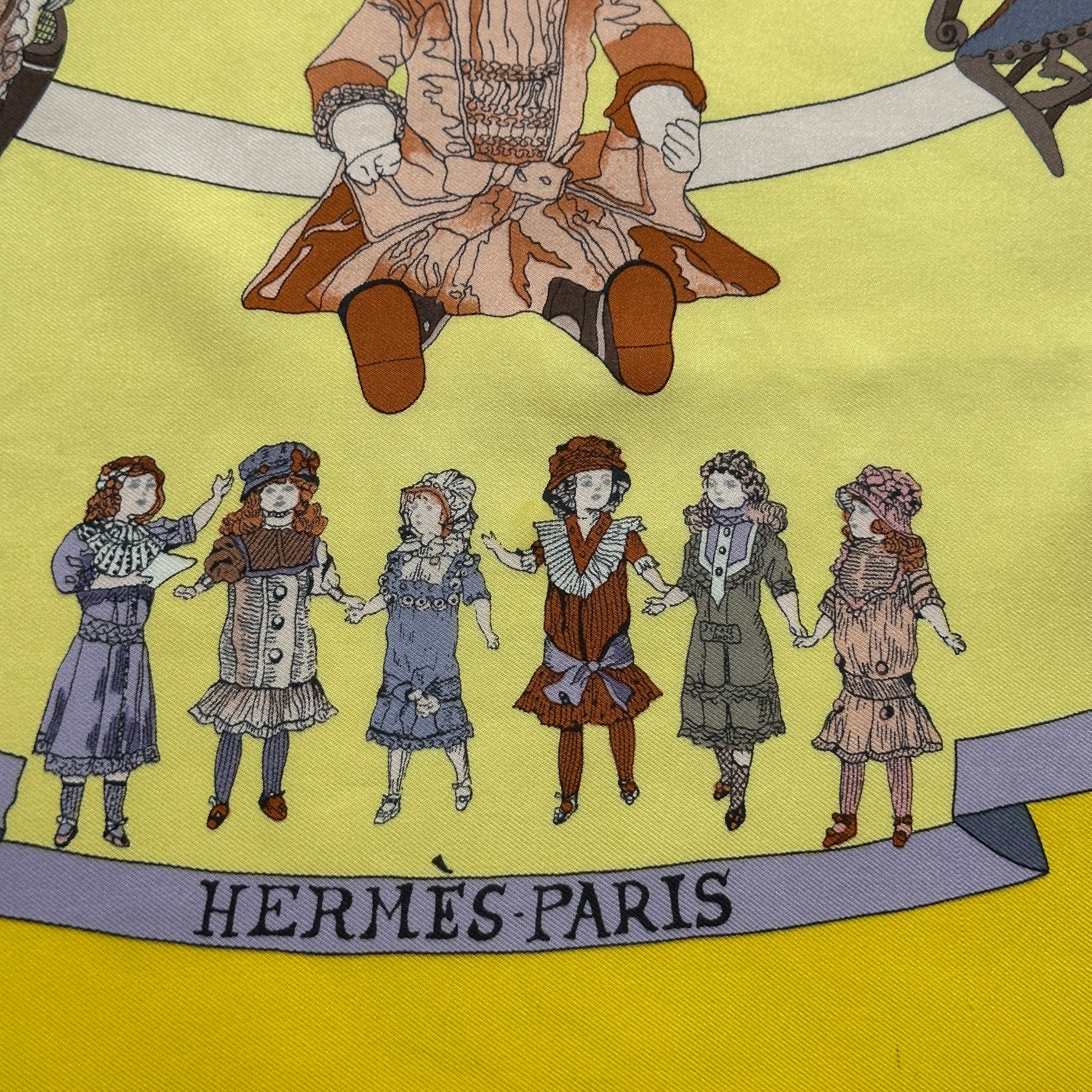 Signature "HERMÈS - PARIS" en bas au centre, entourée d'une farandole de petites figurines et poupées.