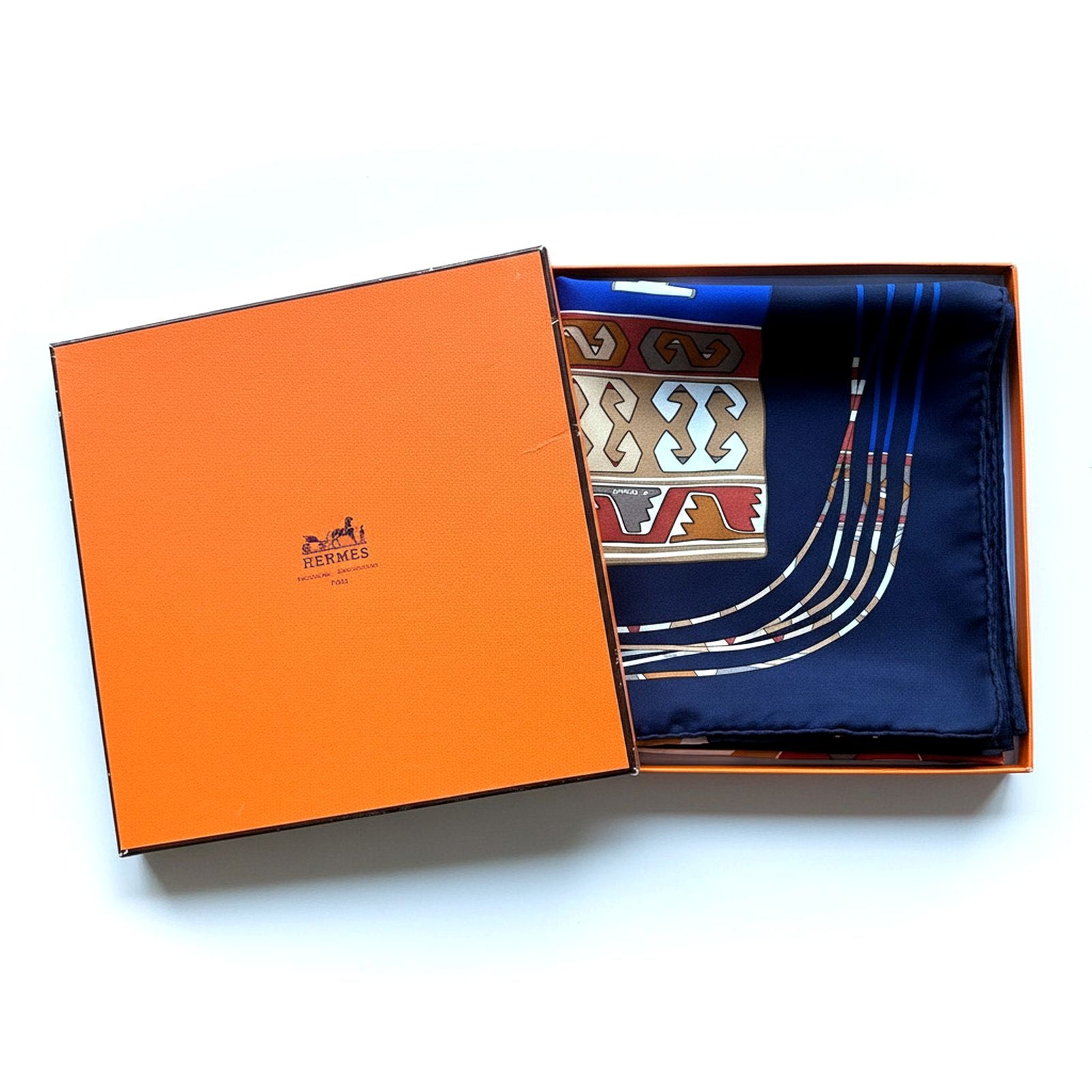 Foulard Hermès Kilim soigneusement plié dans sa boîte orange Hermès